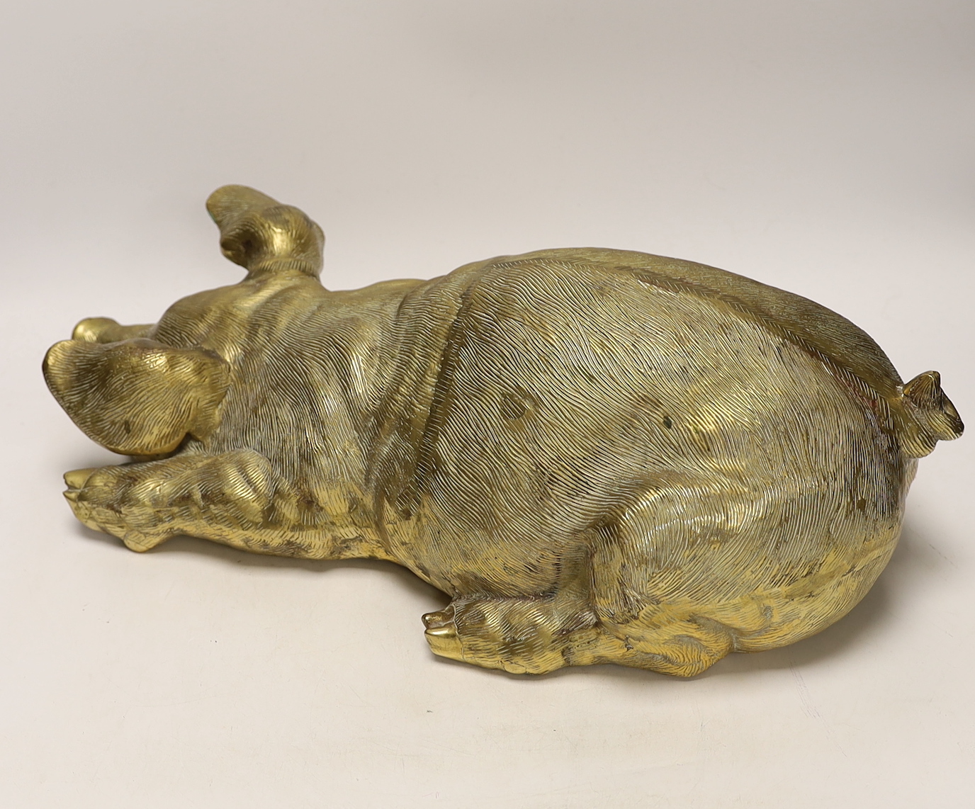 A large hollow cast brass model of a recumbent pig, 46cm long